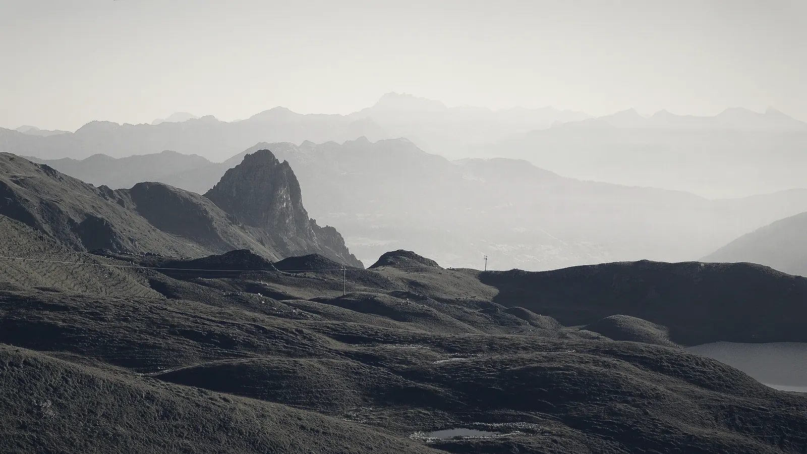 Mist lying between alpine ridges above a lake at first light