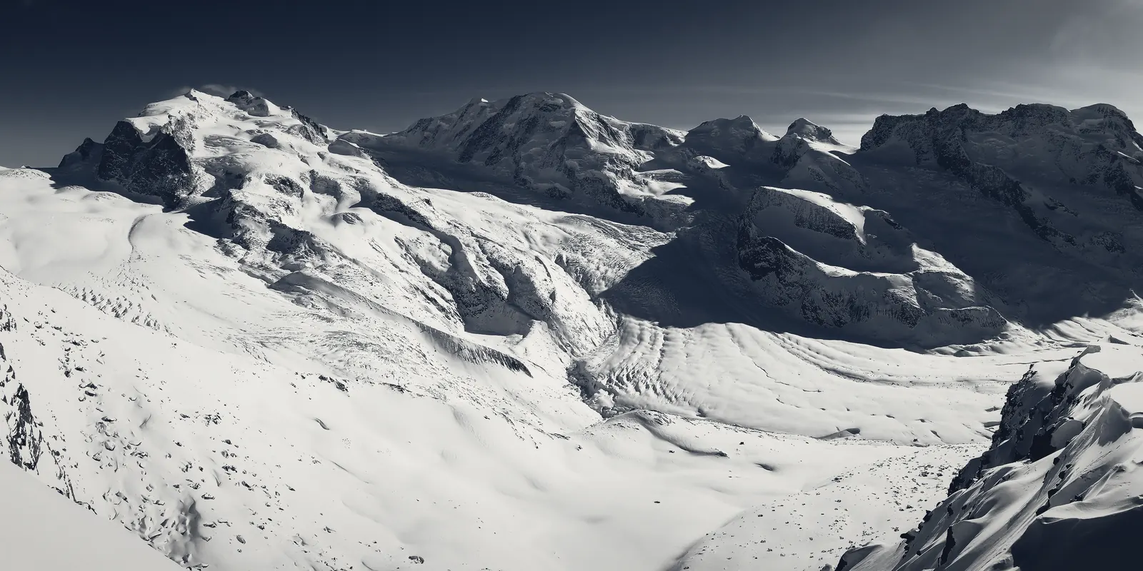 A snow-covered alpine range under a clear sky