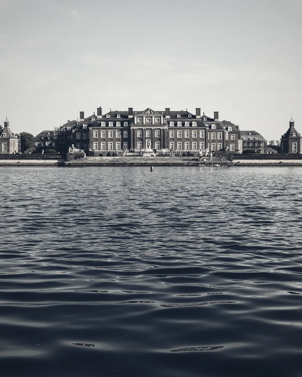 The facade of a European country house across formal grounds