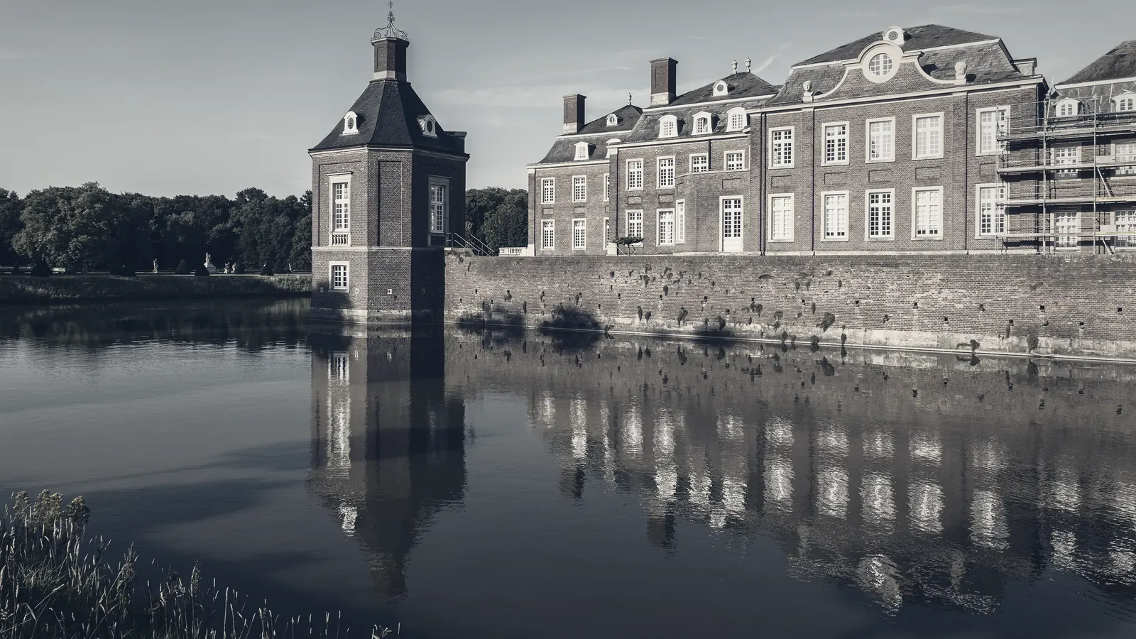 A historic residential estate reflected in still water